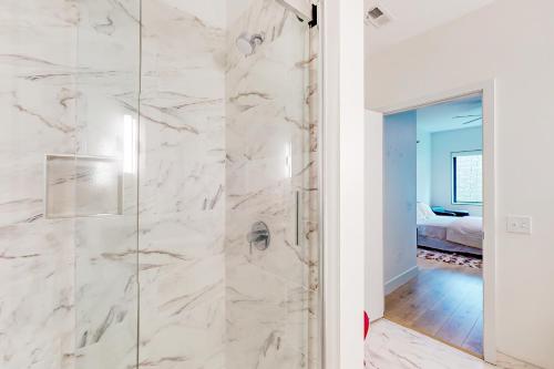 a bathroom with a shower with white marble walls at The Landing in Asheville