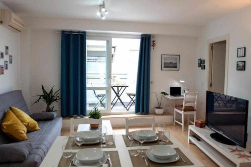 a living room with a couch and a tv at Céntrico apartamento y parking a 200m de la playa in Palamós