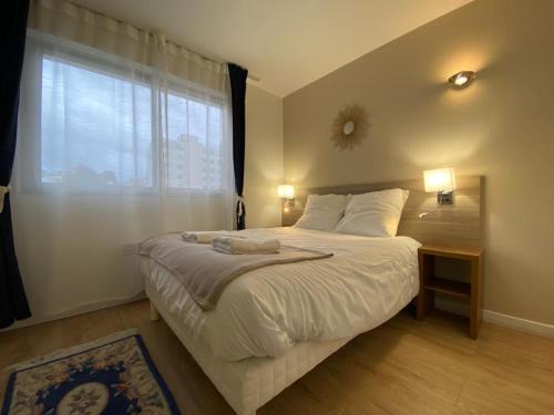 een slaapkamer met een groot bed en een raam bij Le Joan Miro - 100m des thermes in Vichy