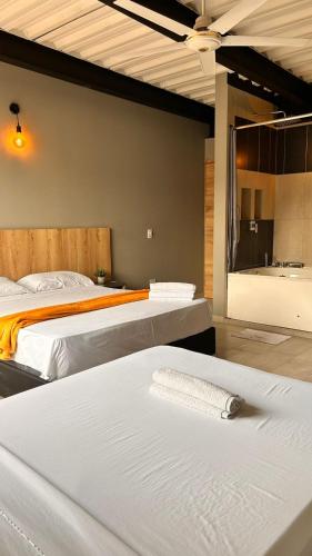 a bedroom with two beds and a bath tub at Seven hotel in Santa Fe de Antioquia