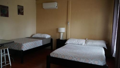 um quarto com 2 camas e uma secretária com um candeeiro em VISTA MIRAVALLES - Rio Celeste Dreams em Bijagua