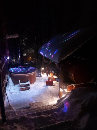 a hot tub in the snow at night at Pensjonat Gościniec Szczyrk , z sauną i jacuzzi in Szczyrk