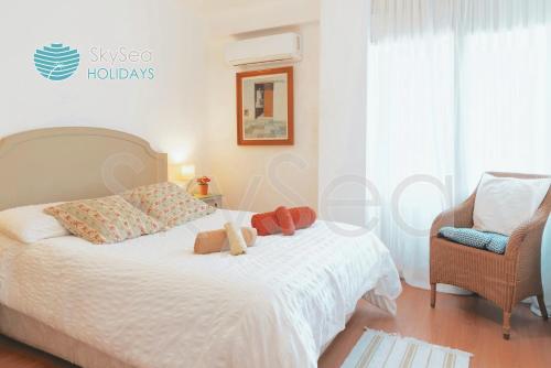a bedroom with a bed with two stuffed animals on it at SkySea Holidays MALAGA BAILEN in Málaga
