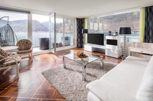 a living room with a white couch and a table at Seehotel Pilatus in Hergiswil