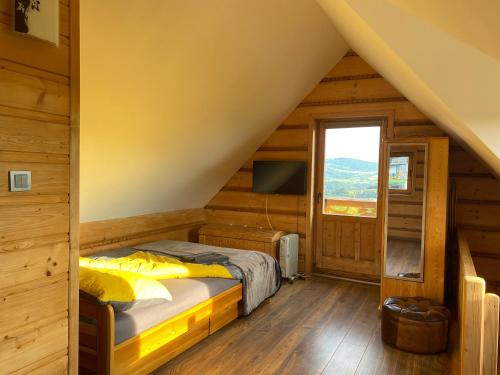 een slaapkamer met een bed in een houten huis bij Tabacówka in Tabaszowa