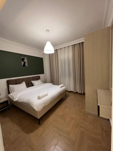 a bedroom with a large bed with a green wall at bedroom (3) apartment of 200 square meters with an outdoor terrace in Umm Uthainah