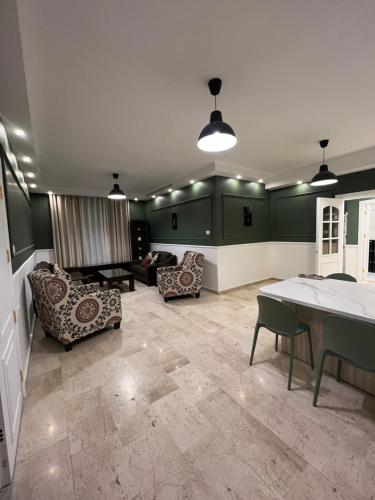 a living room with green walls and a table and chairs at bedroom (3) apartment of 200 square meters with an outdoor terrace in Umm Uthainah