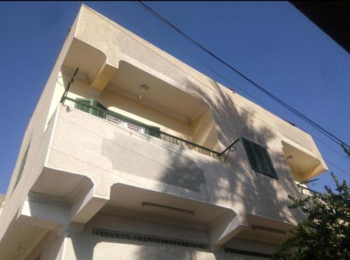 a white building with a balcony on the side of it at Bakar Nubian Guest House in Aswan