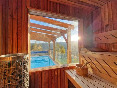 a window in a wooden cabin with a swimming pool at Nad Zalew in Sromowce Wyżne