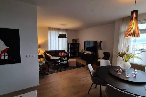 a living room with a table and chairs and a living room at Spectacular apartment, all new with fantastic view in Reykjavík