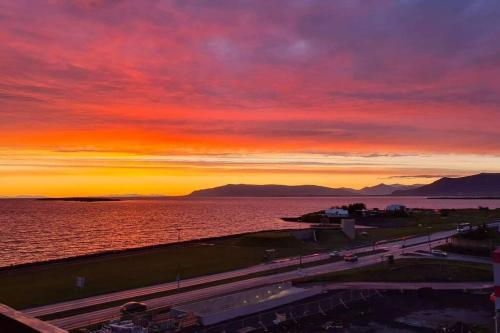 a sunset over the water and a freeway at Spectacular apartment, all new with fantastic view in Reykjavík