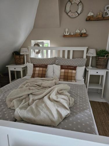 a bed with a blanket on it in a room at Beach House Old in Międzyzdroje