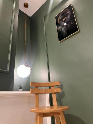 a wooden chair in a room with a lamp at bedroom (3) apartment of 200 square meters with an outdoor terrace in Umm Uthainah
