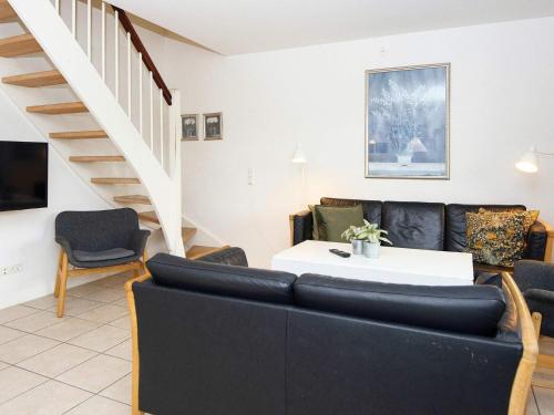 a living room with a couch and a staircase at 8 person holiday home in Gjern-By Traum in Gjern