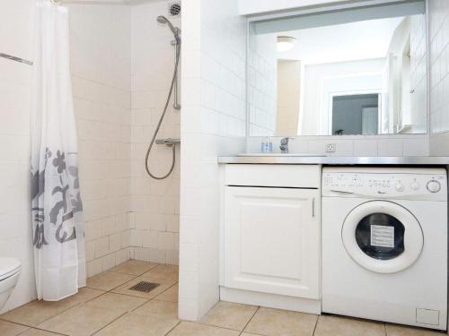 a white bathroom with a washing machine and a mirror at Holiday Home Troldbjergvej IV in Gjern