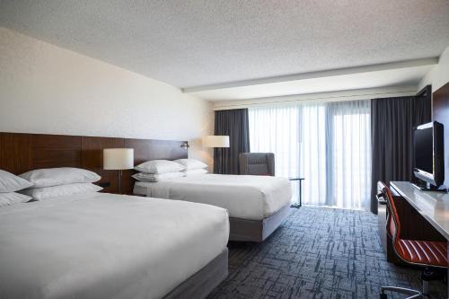 a hotel room with two beds and a flat screen tv at Renaissance Concourse Atlanta Airport Hotel in Atlanta