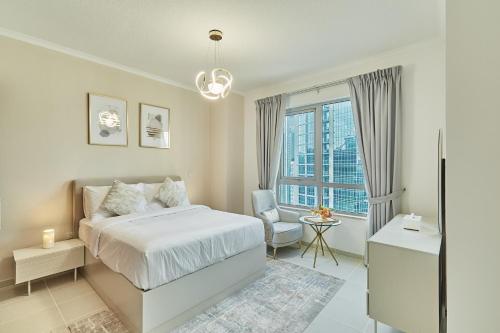 1 dormitorio con 1 cama, 1 silla y 1 ventana en Burj Khalifa Front view & Fountain view Island Paradise 2BR Luxury Apartment Burj residences Golden Homes en Dubái