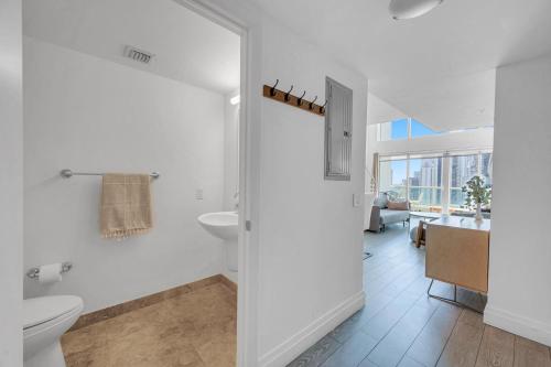 a white bathroom with a toilet and a sink at Iconic 1BR loft Brickell-Waterviews in Miami