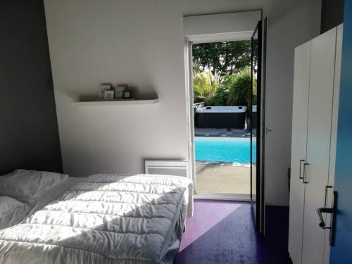 聖屈艾波爾特里厄的住宿－Maison avc Piscine, Spa Etables Mer proche plages，一间卧室配有一张床,享有游泳池的景色