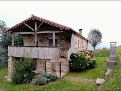 a small brick house with a porch on a yard at Cabaña Pasiega Única in Selaya