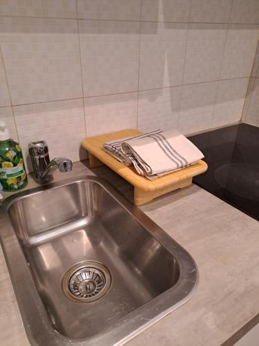 Marie Antoinette-Pala Alpitour- Private Parking في تورينو: حوض المطبخ مع وجود منشفة على لوحة التقطيع