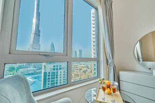a room with a table and a view of a city at Burj Khalifa Front view & Fountain view Island Paradise 2BR Luxury Apartment Burj residences Golden Homes in Dubai