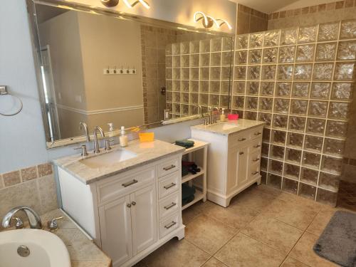 baño con 2 lavabos y espejo grande en Casa in The Cove, en Cabo Coral