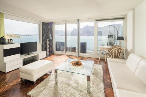 a living room with a white couch and a table at Seehotel Pilatus in Hergiswil