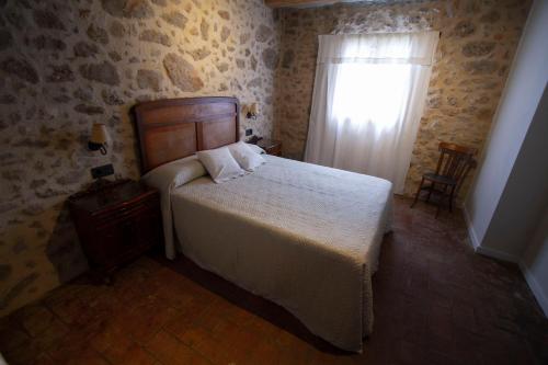 a bedroom with a large bed and a window at La Creu de la Pinya in Berga