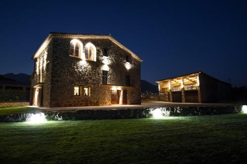 a large stone building with lights on it at night at La Creu de la Pinya in Berga