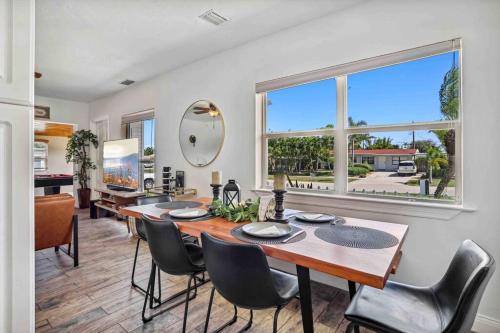 a dining room with a table and chairs and a large window at Beach House/KING BD/Hot Tub/Pool/Fire Pit/Gym/Golf in Lantana