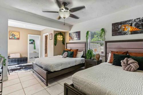 a bedroom with two beds and a ceiling fan at Beach House/KING BD/Hot Tub/Pool/Fire Pit/Gym/Golf in Lantana