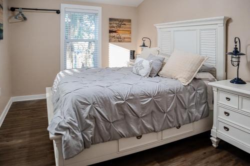 een slaapkamer met een bed met een grijs dekbed en een raam bij Set Sail in Cobb