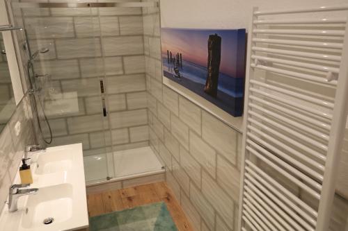 ein Badezimmer mit einem weißen Waschbecken und einer Dusche in der Unterkunft Ferienhaus auf dem Gestüt Lohhof mit wenn gewünscht Kinderreiten in Uchte