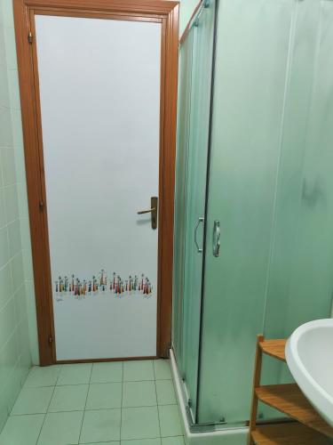 a bathroom with a glass shower door and a sink at Beteyà Hostel Don Bosco in Catania