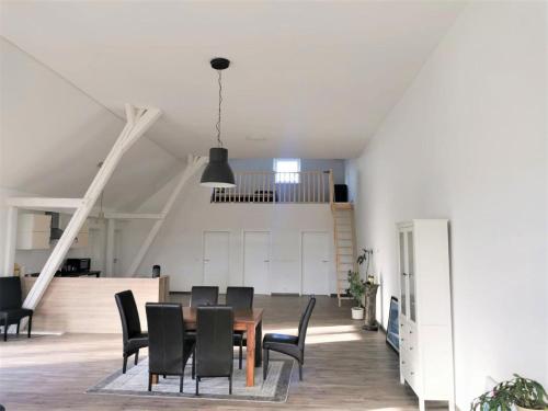 a dining room with a table and black chairs at Eifel Farmhouse Retreat in Auw