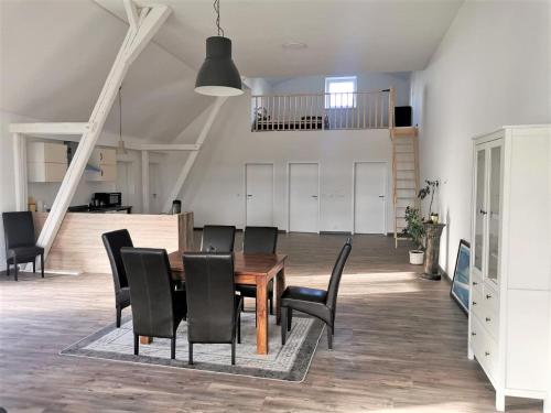 a dining room with a wooden table and black chairs at Eifel Farmhouse Retreat in Auw
