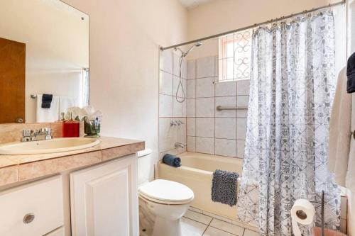 a bathroom with a toilet and a sink and a shower at Shaw Park Gem Apt 12A in Ocho Rios
