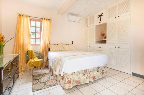 a bedroom with a bed and a desk and a window at Shaw Park Gem Apt 12A in Ocho Rios