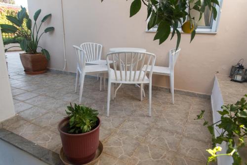 a patio with two chairs and a table and some plants at OAK apartment - Garden, Monodri in Monódhrion