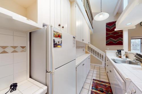 a kitchen with a white refrigerator and a sink at Moose Creek Lodge in Wilson