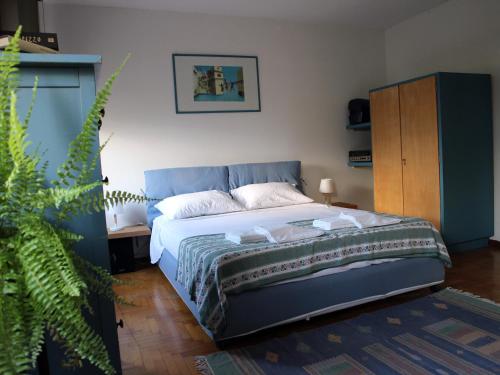 um quarto com uma cama e uma planta em Casa Fantuzzi em Belluno