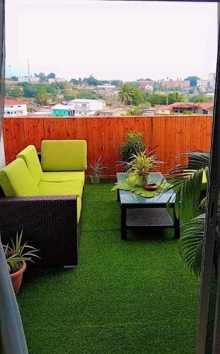 a patio with a couch and a table and a fence at Résidence Dibéla Haut de Guégué in Libreville