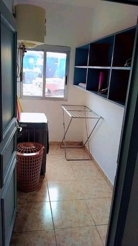 a kitchen with a tiled floor with a table and a window at Résidence Dibéla Haut de Guégué in Libreville