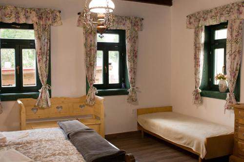 a bedroom with two beds and two windows at Pinkó Vendégház in Noszvaj