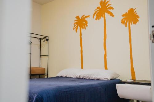 a bedroom with a bed with palm trees on the wall at a 5 min de la playa alberca privada by G P S rentas in Mazatlán