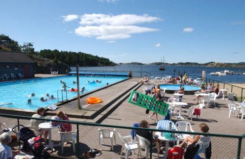 a group of people sitting around a swimming pool at Hytte på sørlandet in Kristiansand