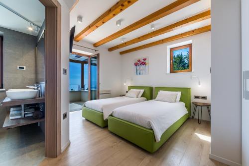 een slaapkamer met 2 bedden, een bad en een wastafel bij Villa Marone in Opatija