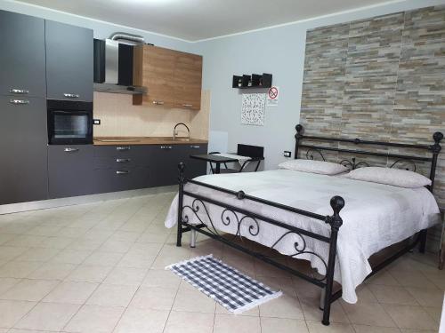 a bedroom with a large bed and a kitchen at B e B House in Castellanza