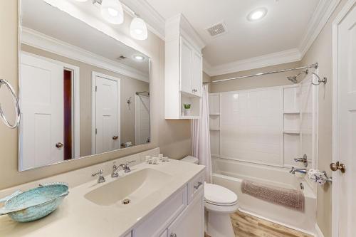 W łazience znajduje się umywalka, toaleta i lustro. w obiekcie Hook Wine and Sinker w mieście Myrtle Beach